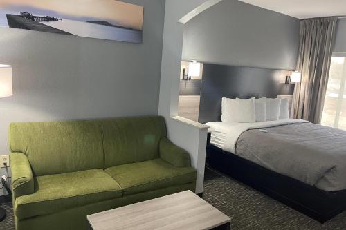 a hotel room with a bed and a couch at Quality Suites Abilene Mall Area in Abilene