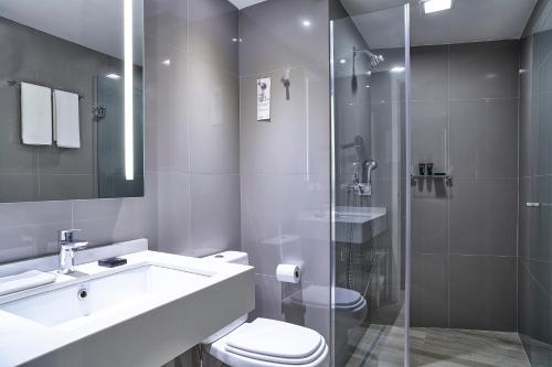 uma casa de banho com um WC, um lavatório e um chuveiro em Radisson Rio de Janeiro Barra no Rio de Janeiro