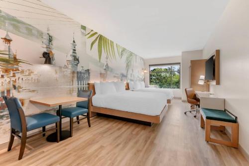 a bedroom with a bed and a desk and a table at Cambria Hotel Tampa-Brandon in Tampa