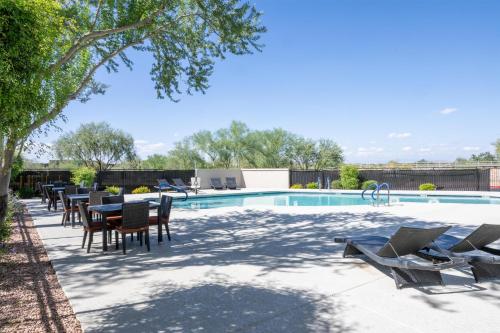 a patio with tables and chairs next to a pool at Hilton Garden Inn North Phoenix Scottsdale in Phoenix