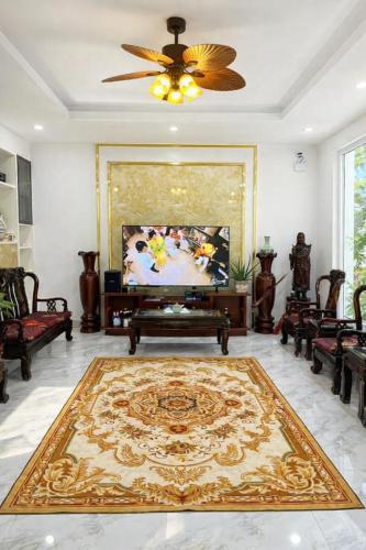 a living room with a television and a large rug at Nhat Long Homestay in Hue