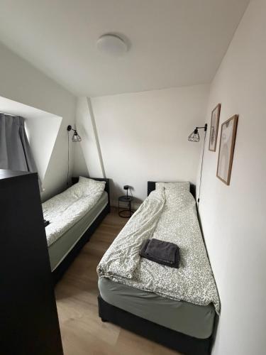 two beds in a room with two lamps at Apartement hotel Stays by ADM in Leiden