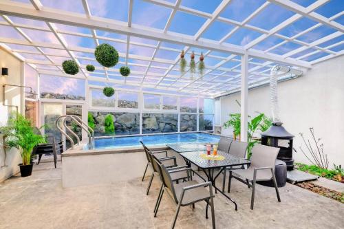 a patio with a table and chairs and a swimming pool at Seogwipo Dawa Pool Villa Pension in Seogwipo