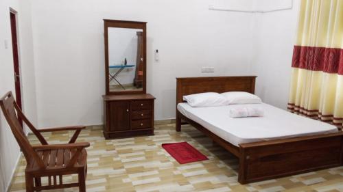 a bedroom with a bed and a mirror and a chair at Villa Rashel in Nikawatawana