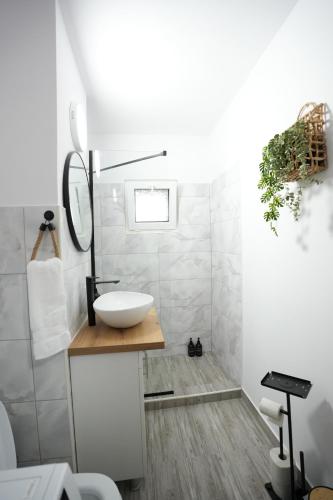 a white bathroom with a sink and a mirror at Lumena - Kingsize Beds, ultracentral, 80mp in Topliţa