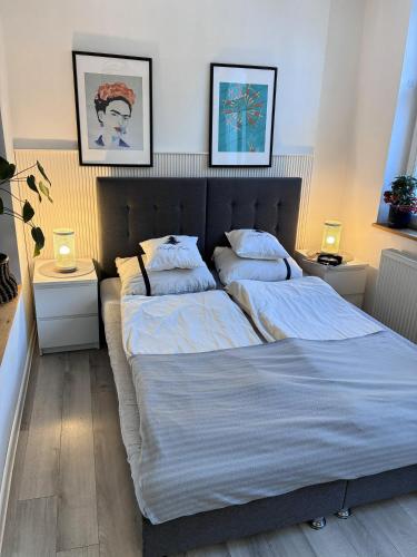 two beds in a bedroom with two lamps on tables at Apartament 100m od morza in Sopot