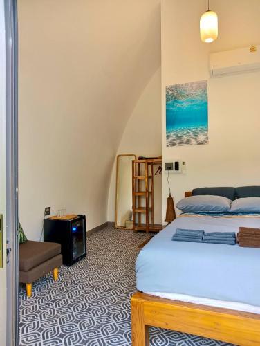 a bedroom with a bed and a chair at Castaway on Mook in Ko Mook