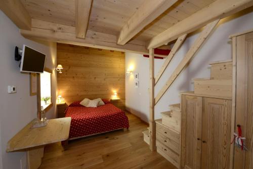 a bedroom with a red bed in a room with stairs at Il Faita in Passo del Tonale