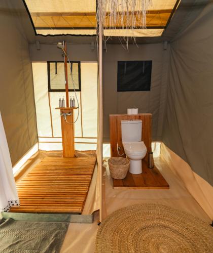 a bathroom with a toilet in a tent at Entepesi Tented Camp in Musiara Campsite