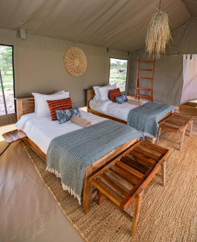 a room with two beds in a tent at Entepesi Tented Camp in Musiara Campsite