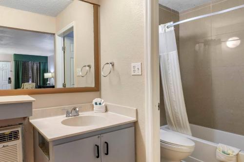 a bathroom with a sink and a toilet and a mirror at Rodeway Inn Clearwater-Dunedin in Clearwater