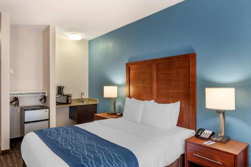 a hotel room with a bed and a telephone at Comfort Inn & Suites Lees Summit - Kansas City in Lees Summit