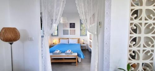 a bedroom with a blue bed with two shoes on it at Nof Beresheet suites in Neot Golan