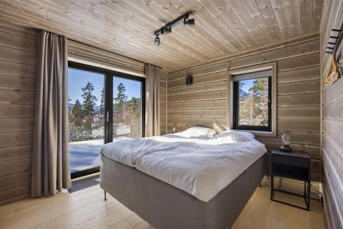a bedroom with a large bed and a large window at Lothlórien Lodge 8p Sauna in Vradal