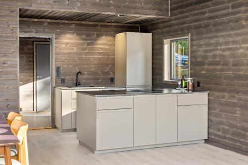 a kitchen with white cabinets and a sink at Berre Veit 6p in Vradal
