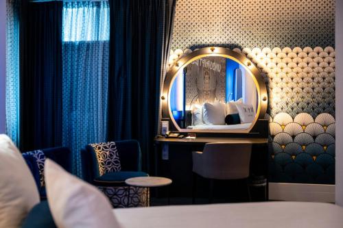 a hotel room with a bed and a mirror at NYX Hotel Amsterdam Rembrandt Square in Amsterdam