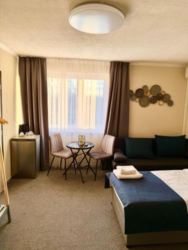 a hotel room with a bed and a table at SergJuli Villa in Plavecký Štvrtok