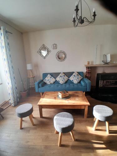 a living room with a blue couch and a table at Gite "La Méluzine" Avallon, Vézelay, Morvan in Magny