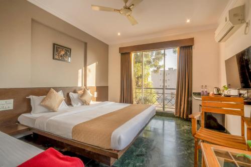 a bedroom with a large bed and a balcony at HOTEL KB's Grand in Shirdi