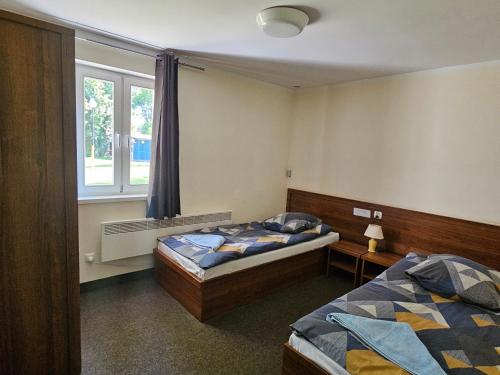 a bedroom with two beds and a window at Hotel i Camping Tramp in Toruń