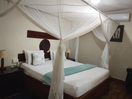 a bedroom with a bed with a canopy at Inkindaba Guest Lodge in Victoria Falls