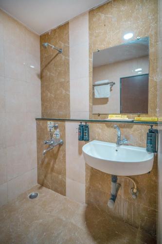 a bathroom with a sink and a mirror at HOTEL KB's Grand in Shirdi