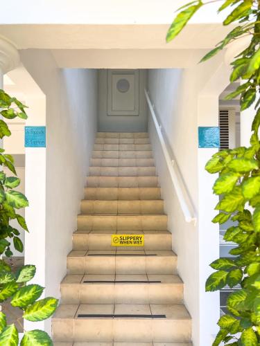 a yellow sign on a stairway in a building at Tropic Drift in Airlie Beach