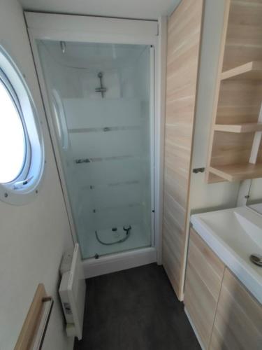 a small bathroom with a shower and a sink at Camping le Rochat Belle Isle in Châteauroux