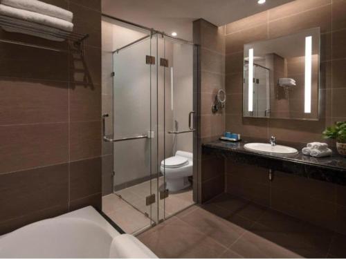 a bathroom with a shower and a toilet and a sink at DN ALT sentafe ppt in Danang