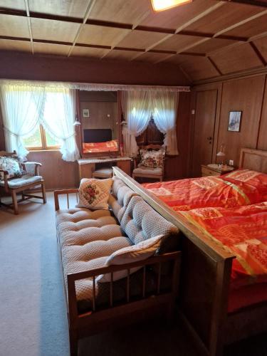 a bedroom with a large bed and a couch at Jagdhütte Breidelsley in Nideggen