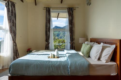 a bedroom with a large bed with a window at SaffronStays Valleyfall in Kotagiri
