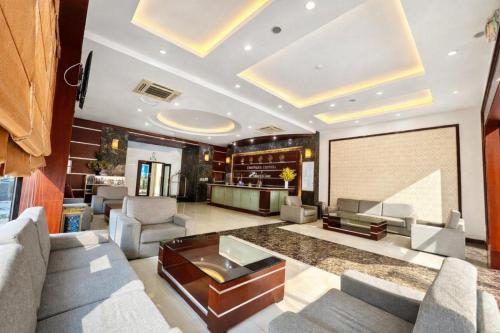 a living room with couches and a projection screen at Central Hotel in Móng Cái