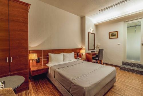a hotel room with a bed and a desk at Hwa Nan Hotel in Yongkang