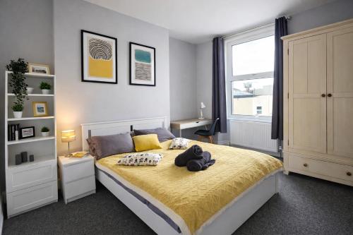 a bedroom with a large bed with a yellow blanket at Spacious Penthouse in Central Plymouth 3 Large Bedrooms in Plymouth