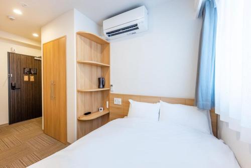 a bedroom with a white bed and a closet at Hopetree 天王寺 in Osaka