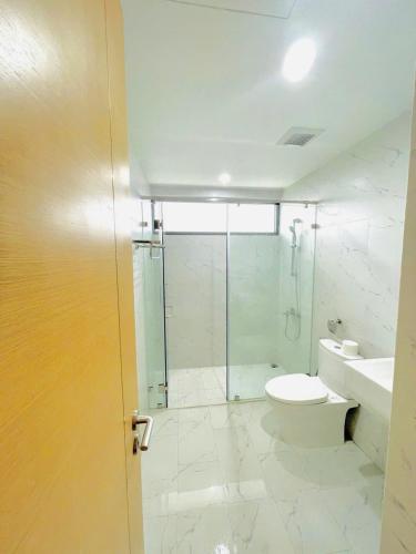a bathroom with a shower and a toilet and a sink at Oceanus Sea View Quy Nhon Apartment in Quy Nhon
