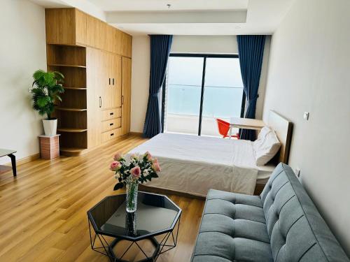 a living room with a couch and a bed at Oceanus Sea View Quy Nhon Apartment in Quy Nhon