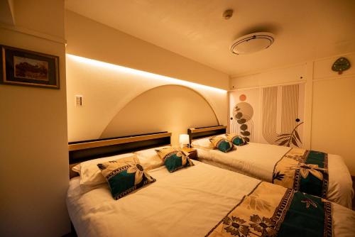 two beds in a hotel room with two at Happy Osaka City in Osaka