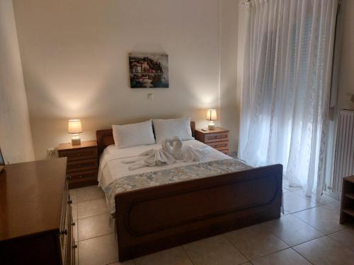 a bedroom with a bed and two lamps and a window at Hellen's Summer house in Keramoti