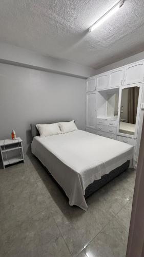 a white bedroom with a large bed and a mirror at 2 bedroom Flat in Namaka,Nadi in Nadi