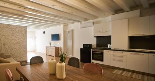 a kitchen and living room with a wooden table in a room at Le Mura Minicase int 3 in Castelfranco Veneto