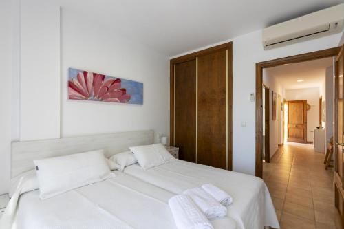 a bedroom with a white bed with towels on it at House Miramar almuñecar in Almuñécar