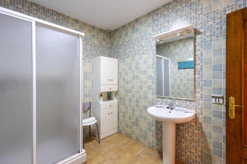 a blue tiled bathroom with a sink and a shower at House Miramar almuñecar in Almuñécar