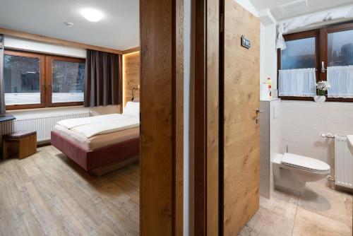 a small room with a bed and a toilet at Hölzl Bed & Breakfast in Neukirchen am Großvenediger