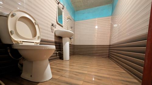 a bathroom with a toilet and a sink at Prasada Resort in Badulla