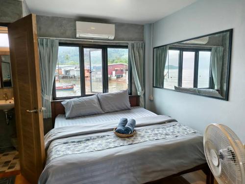 a bedroom with two beds and two windows at Poohry Seaview in Ko Lanta