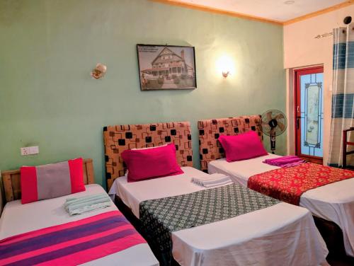 a room with two beds with pink pillows at Prasada Resort in Badulla