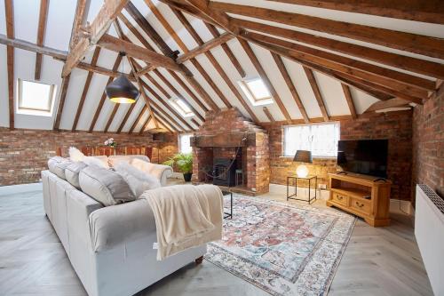 a living room with a white couch and a fireplace at Fantastic Grade II listed renovated coach house in Hull