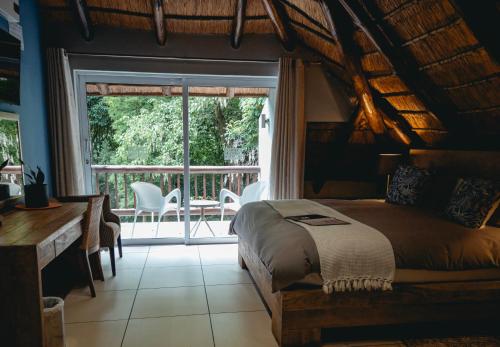 a bedroom with a bed and a large window at Highveld Splendour Boutique Bed and Breakfast in Ermelo
