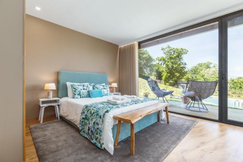 a bedroom with a bed and a large window at Casas De Bouro 2 Casa Dos Jarros in Terras de Bouro